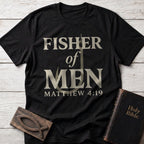Fisher of Men t-shirt in Black — Matthew 4:19 Christian tee flat lay with Holy Bible and ichthys on whitewashed wood