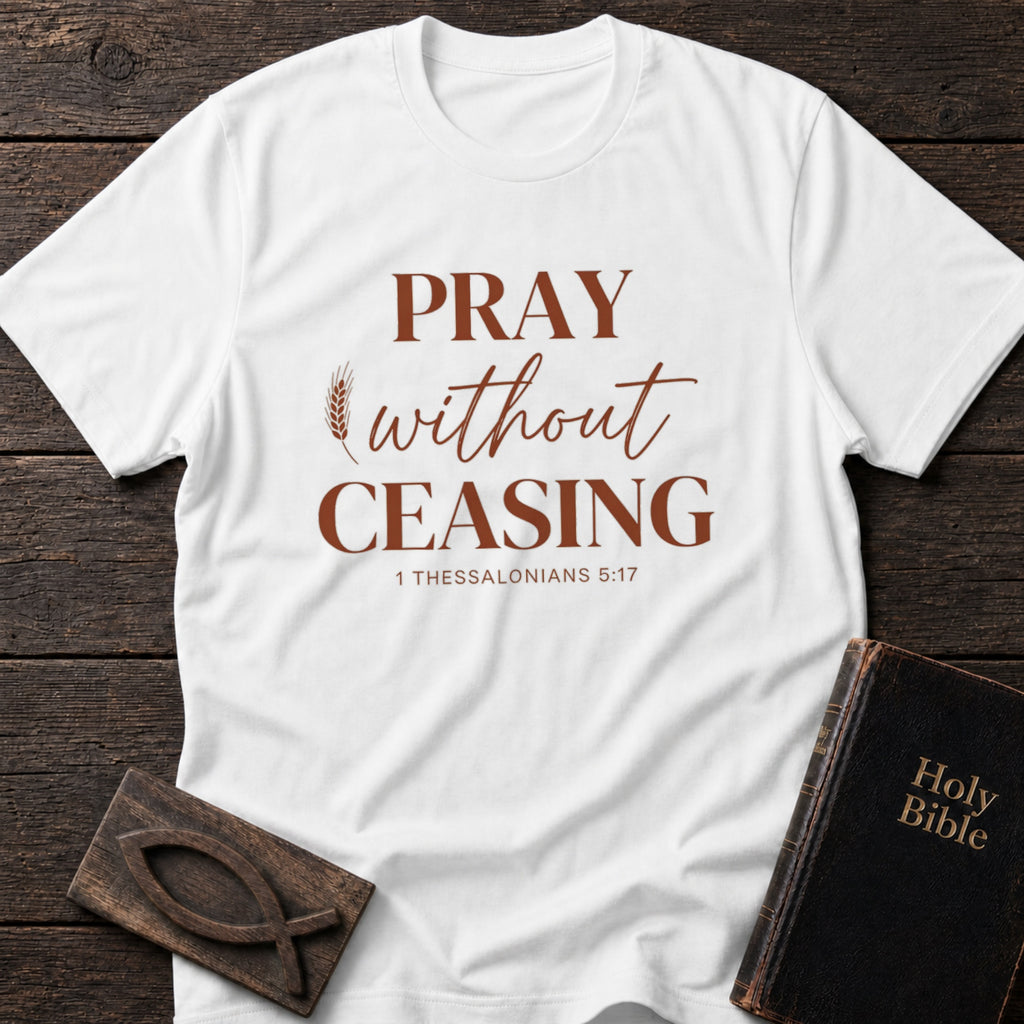 Pray Without Ceasing t-shirt in White — 1 Thessalonians 5:17 Christian tee flat lay with Holy Bible and ichthys on dark wood