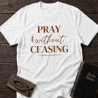 Pray Without Ceasing t-shirt in White — 1 Thessalonians 5:17 Christian tee flat lay with Holy Bible and ichthys on dark wood