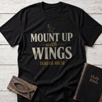 Mount Up With Wings t-shirt in Black — Isaiah 40:31 Christian tee flat lay with Holy Bible and ichthys on whitewashed wood