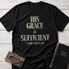 His Grace Is Sufficient t-shirt in Black — 2 Corinthians 12:9 Christian tee flat lay with Holy Bible and ichthys on whitewashed wood