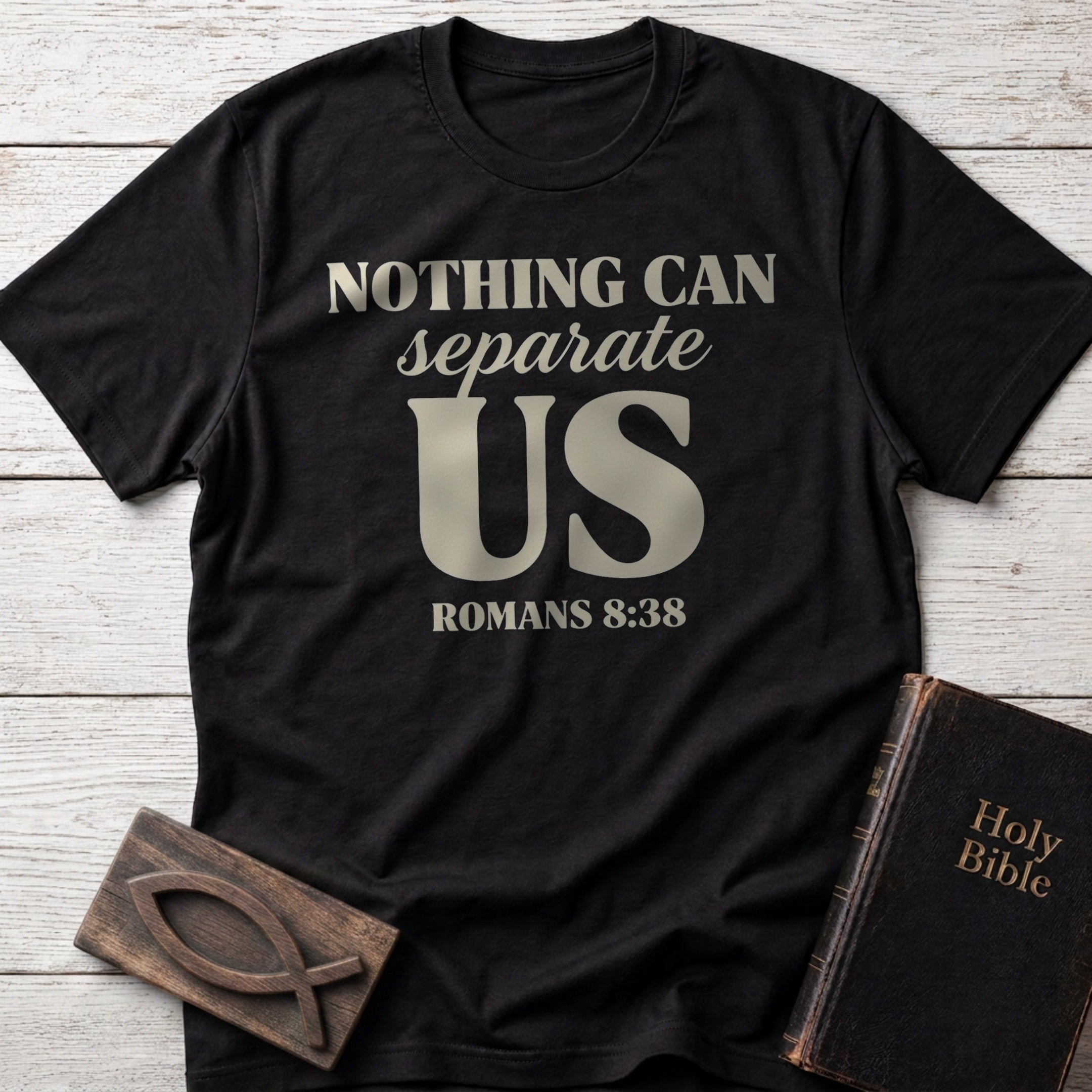 Nothing Can Separate Us t-shirt in Black — Romans 8:38 Christian tee flat lay with Holy Bible and ichthys on whitewashed wood