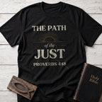 The Path of the Just t-shirt in Black — Proverbs 4:18 Christian tee flat lay with Holy Bible and ichthys on whitewashed wood