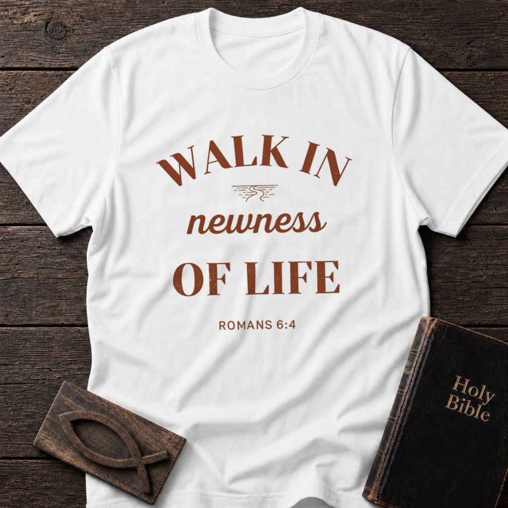 Walk in Newness of Life t-shirt in White — Romans 6:4 Christian tee flat lay with Holy Bible and ichthys on dark wood