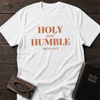 Holy and Humble t-shirt in White — Micah 6:8 Christian tee flat lay with Holy Bible and ichthys on dark wood
