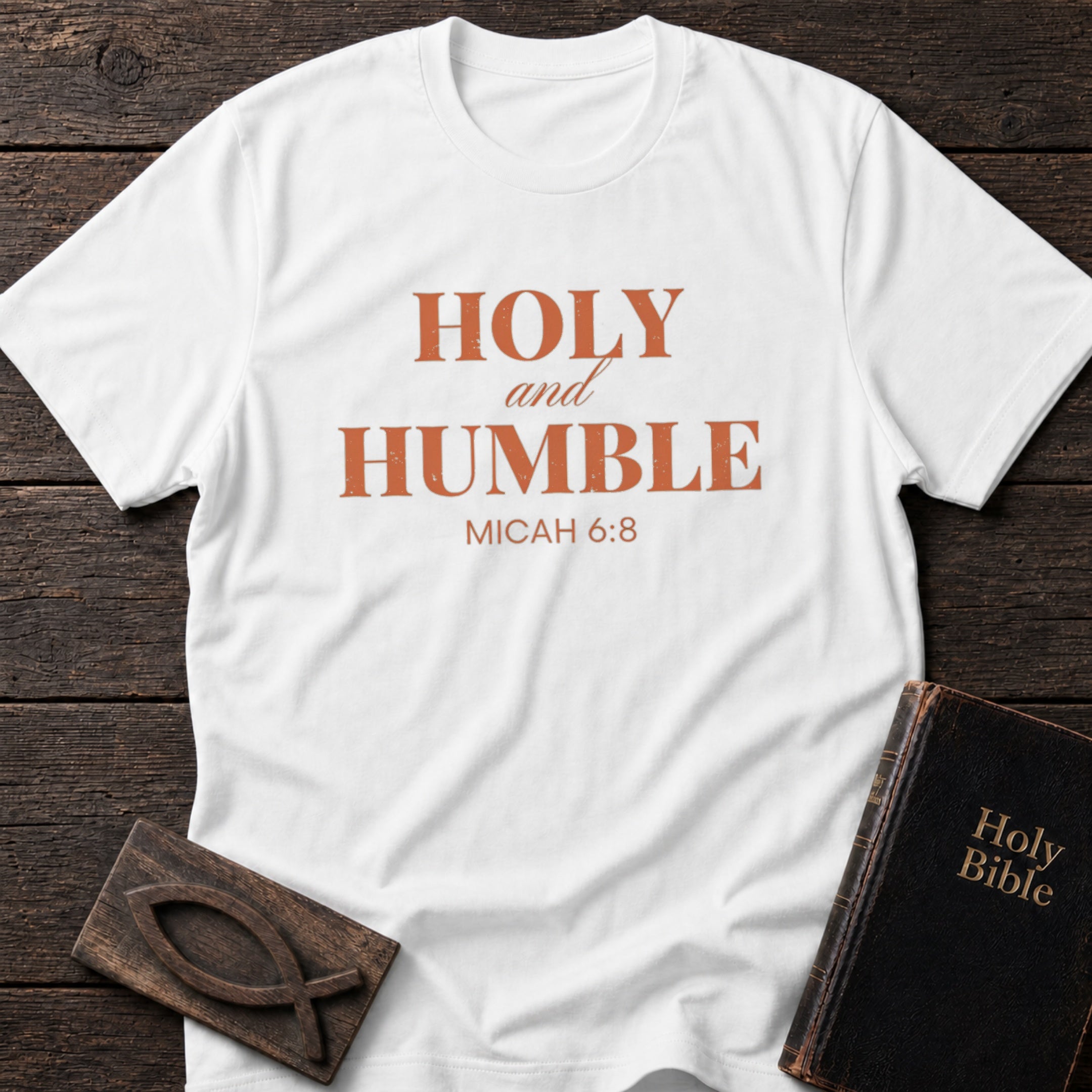 Holy and Humble t-shirt in White — Micah 6:8 Christian tee flat lay with Holy Bible and ichthys on dark wood