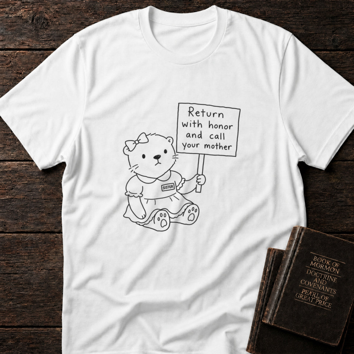 Return with Honor and Call Your Mother Sister t-shirt in White — sister missionary teddy bear tee flat lay with scripture books on dark wood